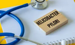 Stetoskop i klocki z napisem "Helicobacter pylori" symbolizują problemy zdrowotne, w tym potencjalne helicobacter pylori objawy psychiczne.