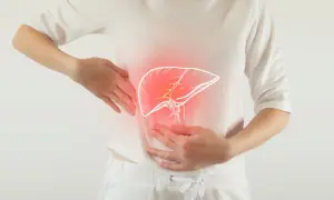 Kobieta trzyma się za brzuch, gdzie widoczna jest powiększona wątroba. Czy powiększona wątroba może się zmniejszyć?