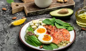 Talerz z łososiem, jajkami, awokado, serem i szpinakiem. Idealne składniki na dietę keto.