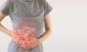 Osoba trzymająca się za brzuch, gdzie widoczny jest zarys wątroby. Może to symbolizować problemy trawienne lub skutki uboczne enzymów trawiennych.