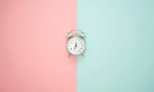 Budzik na tle różowo-miętowym. Czas na dietę 8/16.