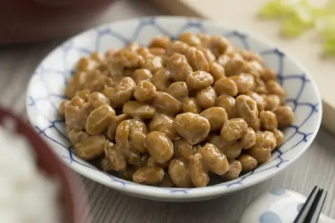 Miseczka z nattō, tradycyjną japońską potrawą. Choć nattokinaza ma wiele zalet, warto pamiętać o potencjalnych skutkach ubocznych.
