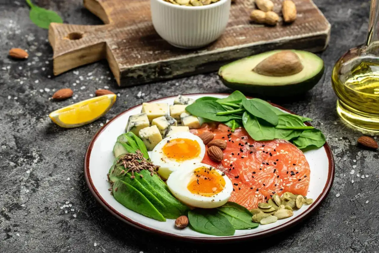 Talerz z łososiem, jajkami, awokado, serem i szpinakiem. Idealne składniki na dietę keto.